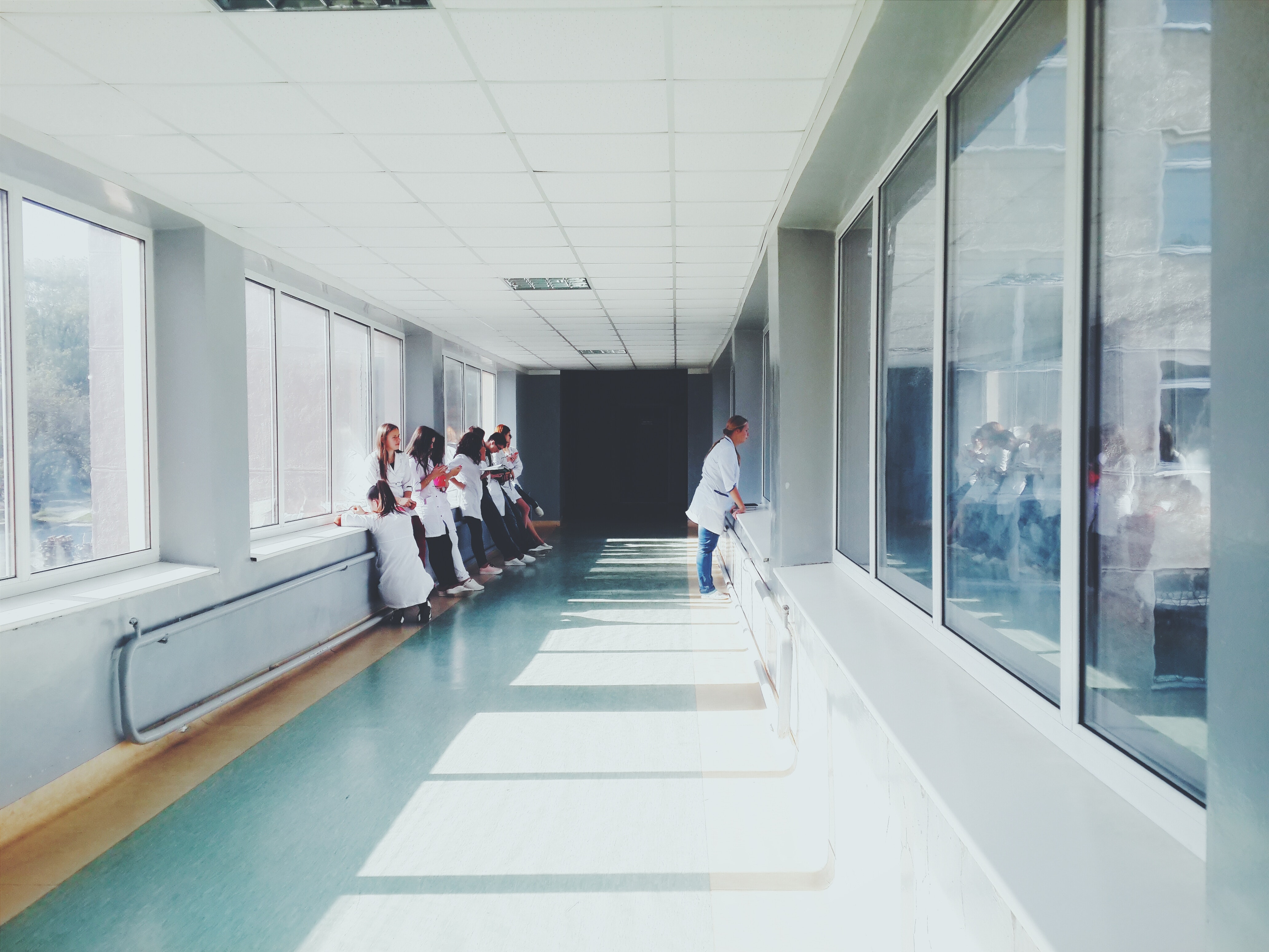 Woman in white shirt standing near glass window inside room
